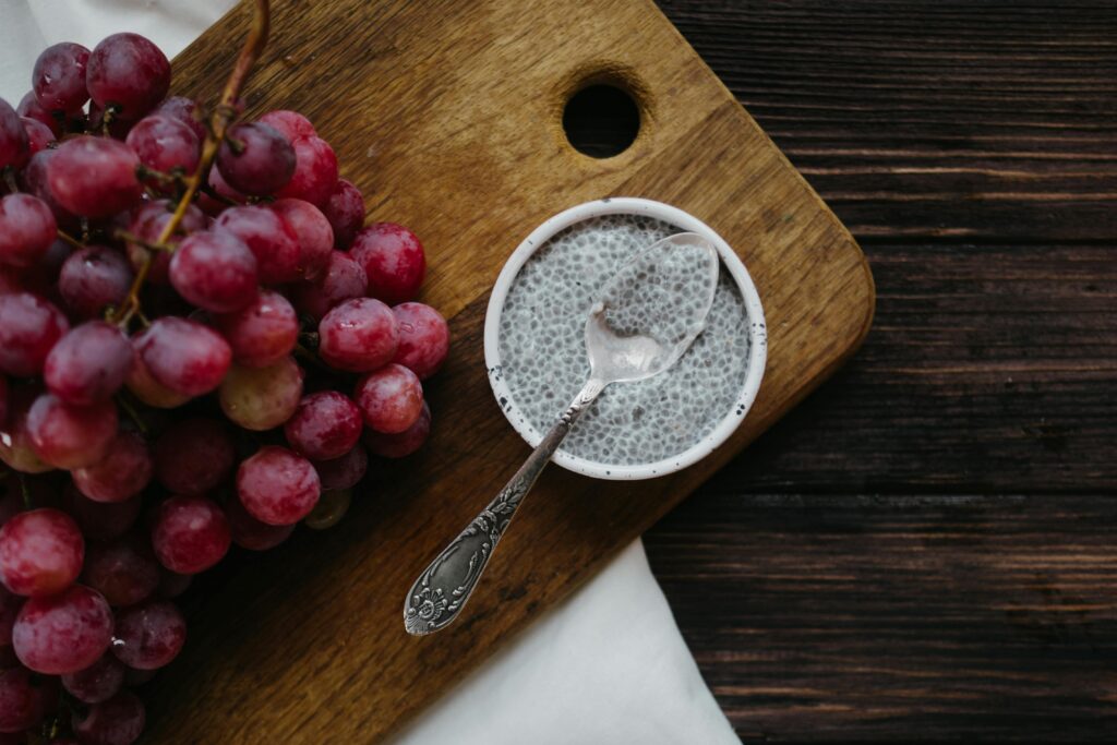 pexels-photo-5645120-5645120 Healthy chia pudding with red grapes on rustic wooden background.